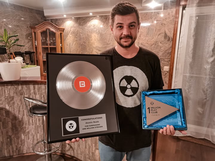 Slavebell holding BeatStars and Airbit awards for Atomic Beats